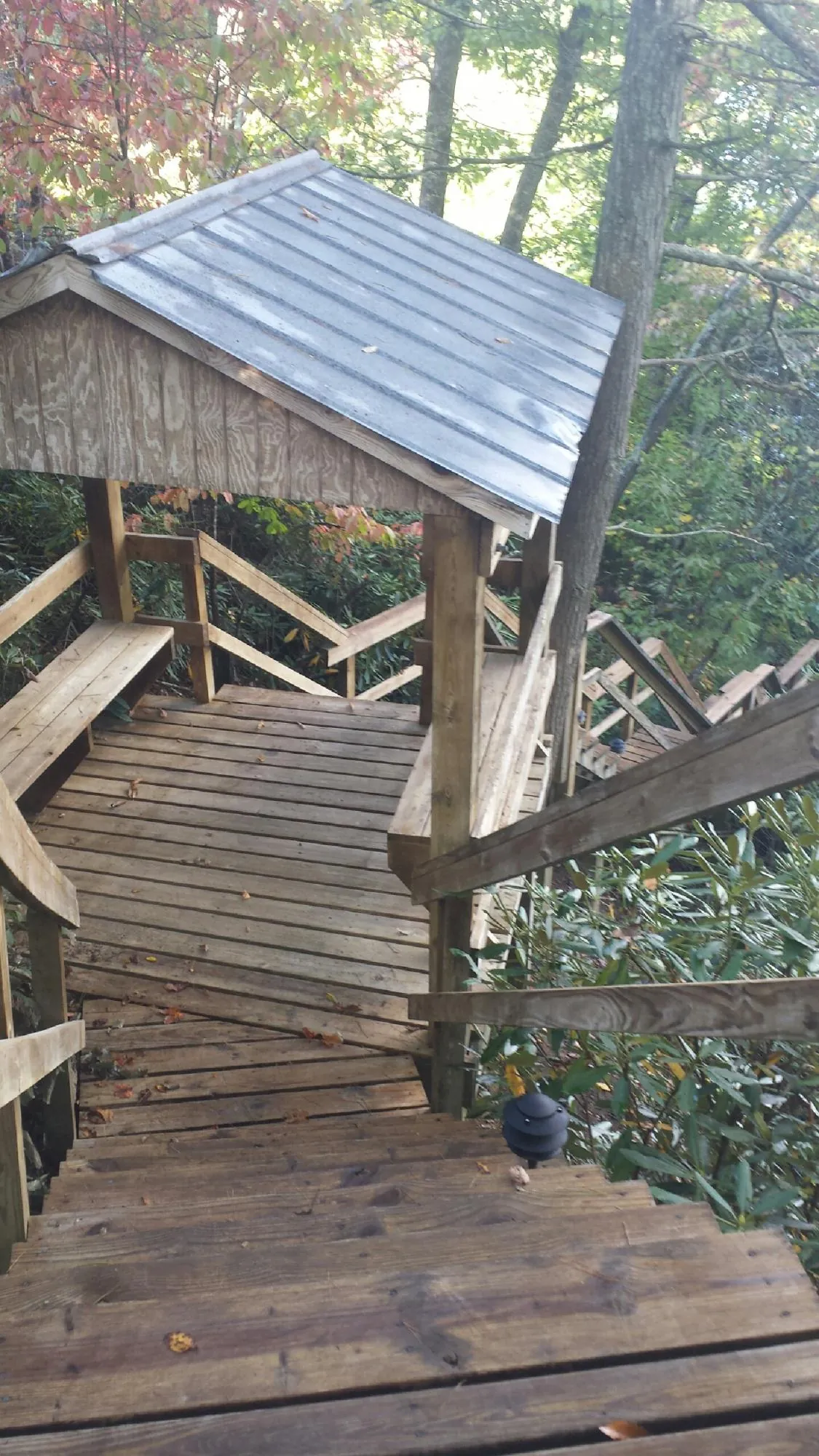 Metal roofed shelter over wooden steps on a wooded walkway — Skylight Repair & Installation work by our crew in Wichita Falls
