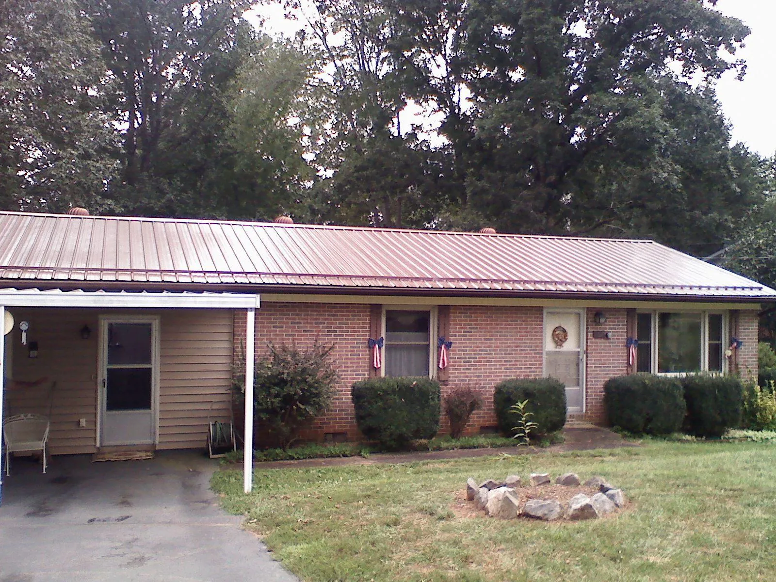 Bronze metal roof and carport on a brick ranch home — Roof Repair work by our crew in Wichita Falls