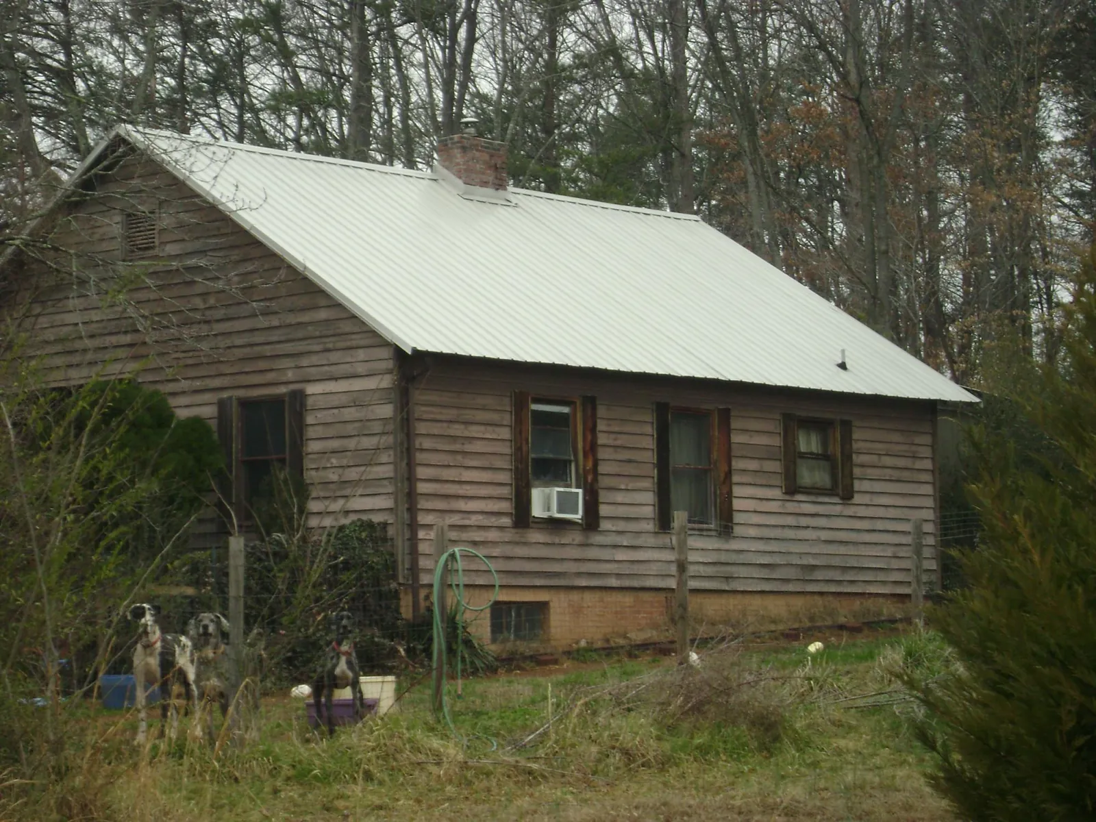 White metal roof on an old wood sided farmhouse, from a Metal Roof Installation job in Wichita Falls